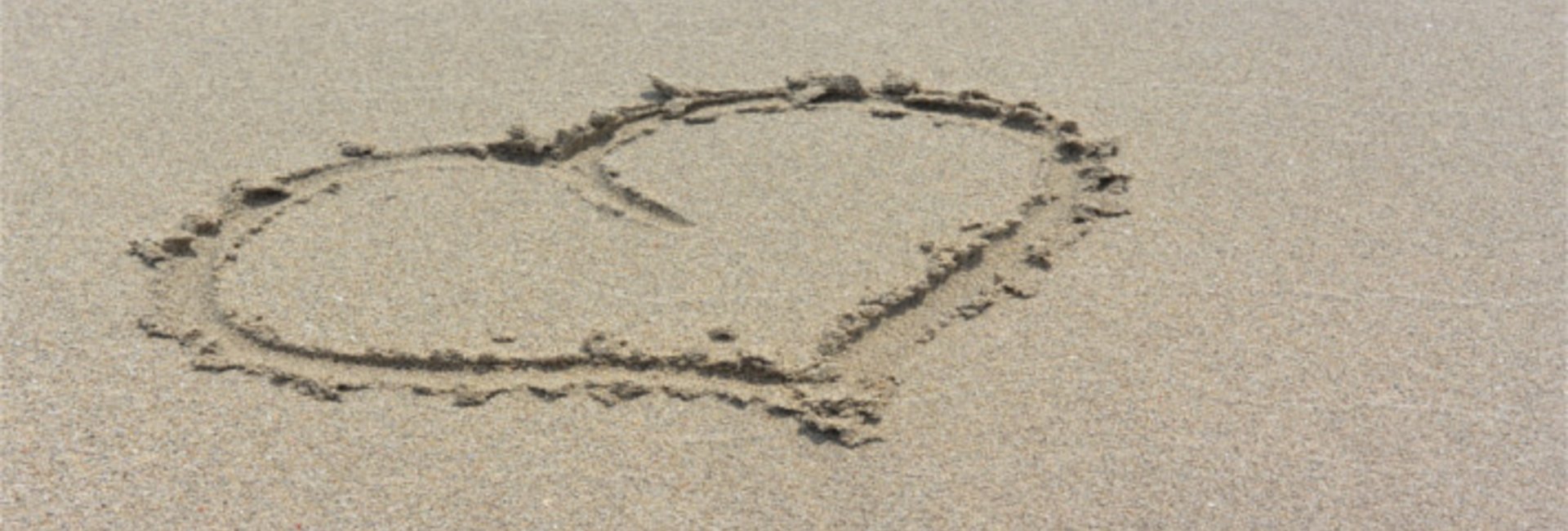 Das Bild zeigt ein in Sand gemaltes Herz.