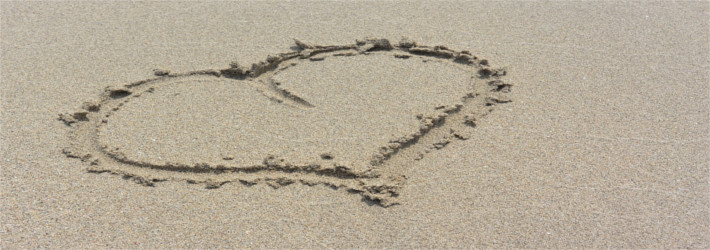 Das Bild zeigt ein in Sand gemaltes Herz.